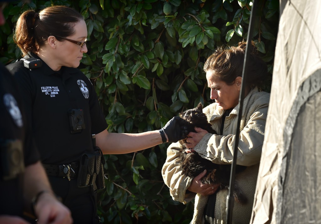 Cpl. Ginny Johnson, left, of the Homeless Liaison Unit, talks to a homeless woman holding a cat she named Chelsea. Photo by Steven Georges/Behind the Badge OC