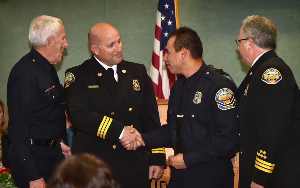Orange County Fire Authority Reserve Firefighter Eddie Barrera, third from left, receives the Meritorious Service Award from Battalion Chief Rob Capobianco, left, Division Chief Jeff Adams and Division Chief John Abel, right. Photo by Steven Georges/Behind the Badge OC