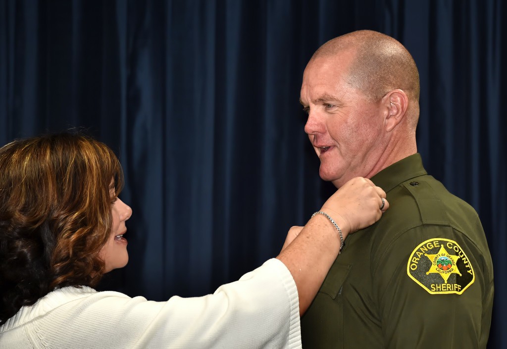 Deputy Arvar Elkins has his new badge pined to him by his wife, Kari Elkins, during a OCSD lateral swearing in ceremony. Photo by Steven Georges/Behind the Badge OC