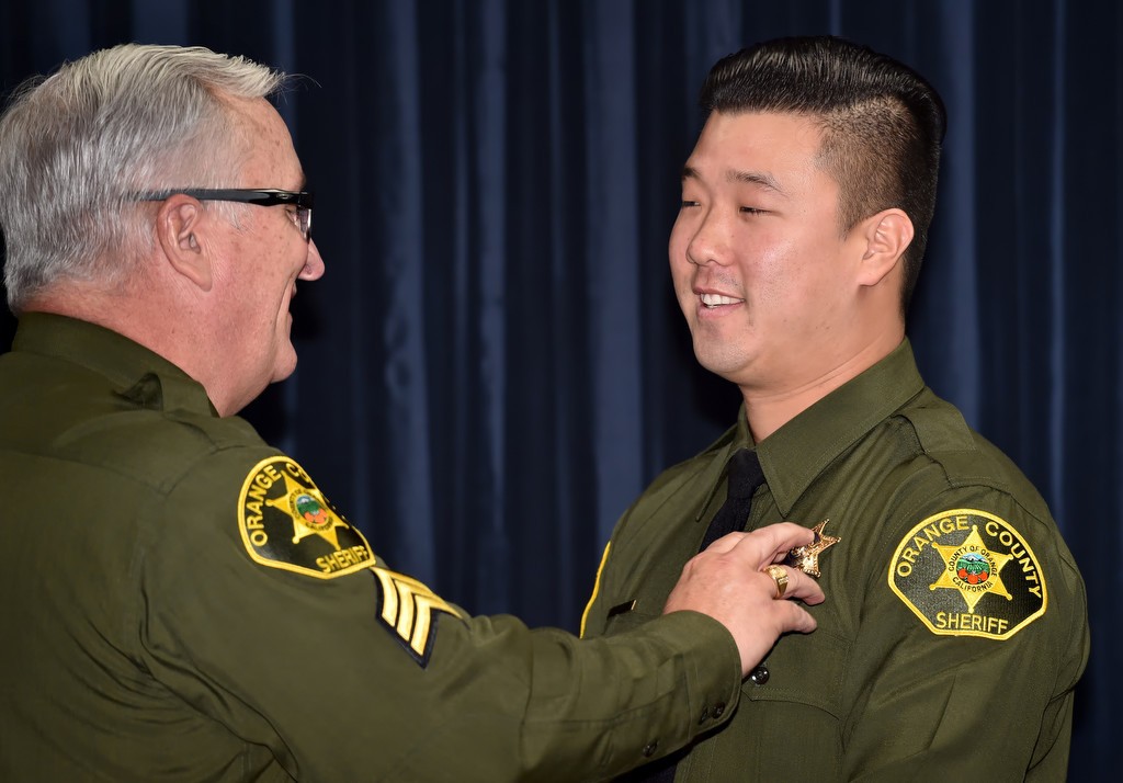 Deputy Bongki Min receives his new badge from Sgt. Randy Taylor during a swearing in ceremony for laterals at the OCSD. Photo by Steven Georges/Behind the Badge OC