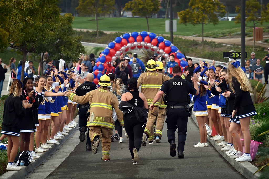 Participants, that include members of the Fountain Valley Police Officers Association and Fountain Valley Firefighters Association, approach the finish line as they run in full gear for the Fountain Valley Community Foundation 5K Fun Run at Mile Square Park. Photo by Steven Georges/Behind the Badge OC