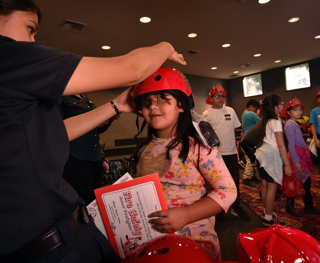 Five-year-old Alexis Toro gets fitted for a new bicycle helmet, courtesy of AF&R. Photo by Steven Georges/Behind the Badge OC