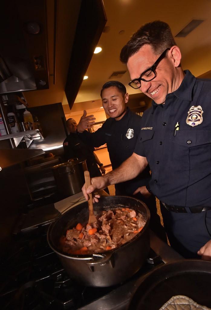 Firefighter John Bugay of OCFA’s Station 61, left, and Engineer/Paramedic Michel Bowidowicz of AF&R’s Station 11, cook beef stew for the crew at Anaheim Fire’s Station 11. Photo by Steven Georges/Behind the Badge OC