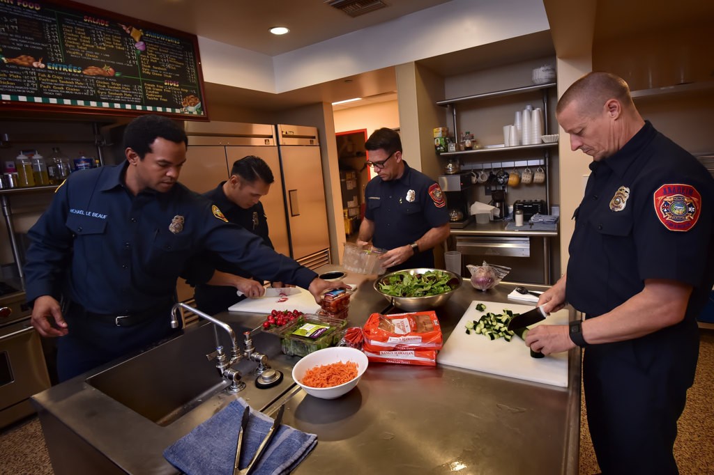 Michael Le Beauf, left, and John Bugay of OCFA’s Station 61 and Michel Bowidowicz and Denny Munson of AF&R’s Station 11, right, prepare dinner at Anaheim’s Fire Station 11. Photo by Steven Georges/Behind the Badge OC