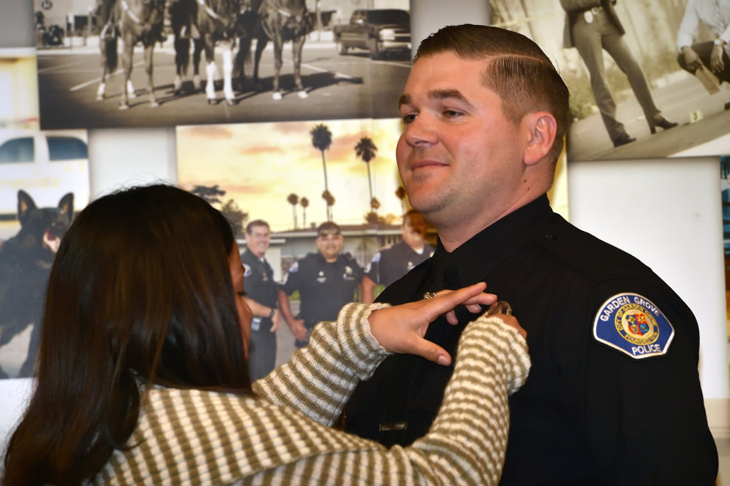 Joshua Brannon, a lateral from Los Angeles PD, gets his new Garden Grove PD badge pined to him by his wife Sara Brannon during a swearing in ceremony. Photo by Steven Georges/Behind the Badge OC