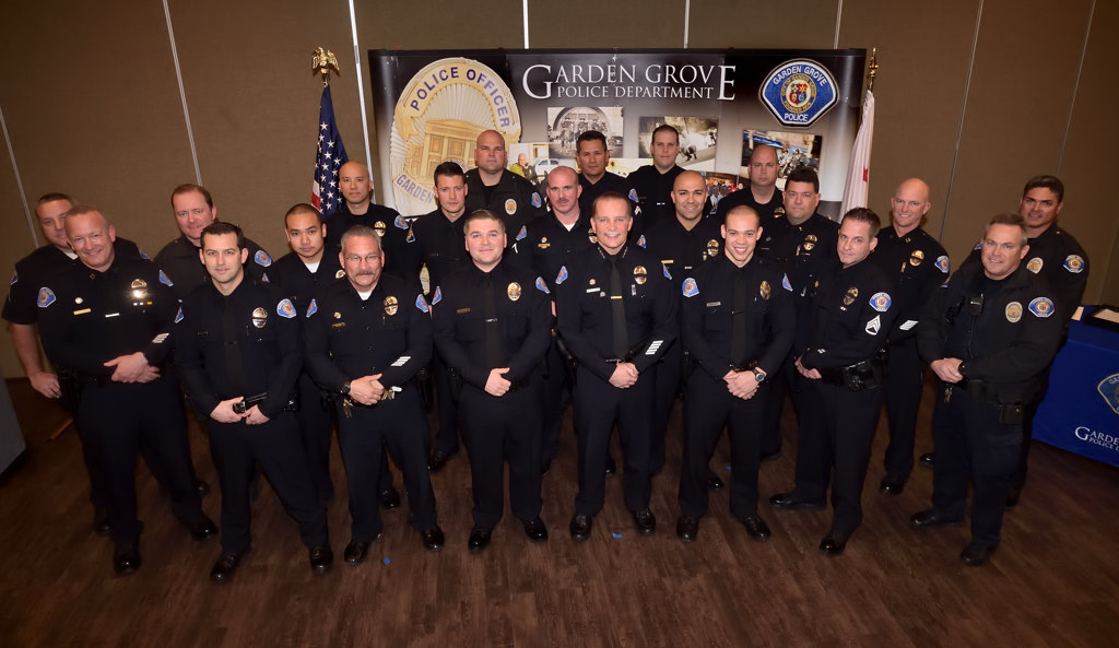 Garden Grove police officers gather with Police Chief Todd Elgin, center as he stands next to the two new lateral officers Kris Kelley, left, and Joshua Brannon right of the chief at the conclusion of the swearing in ceremony. Photo by Steven Georges/Behind the Badge OC