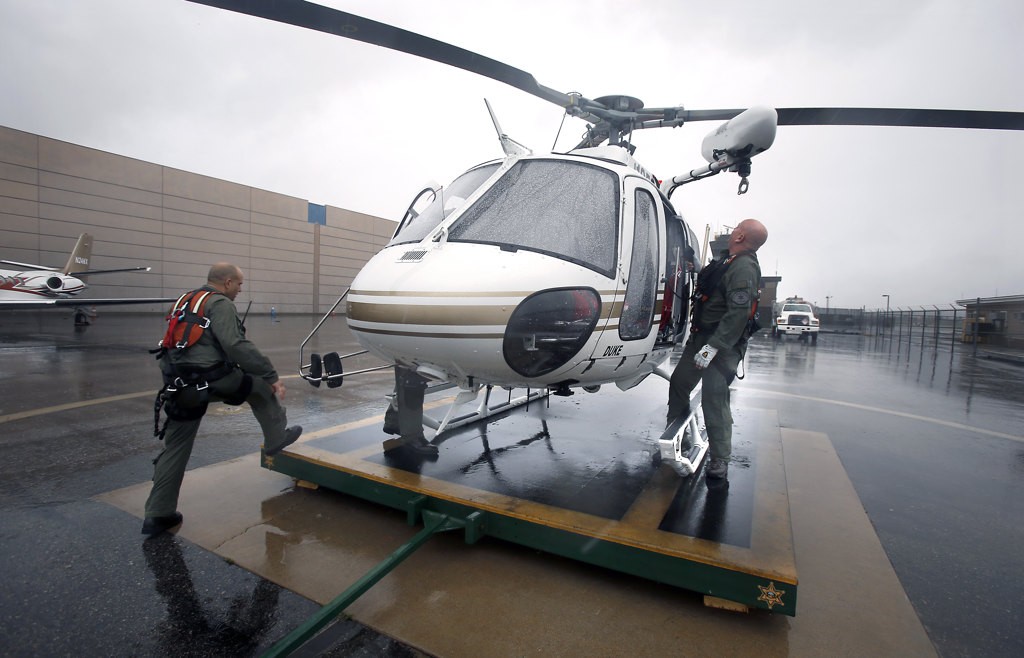OCSD's Michael De Laby and Joe Kantar with one of the department's rescue helicopters. Photo by Christine Cotter
