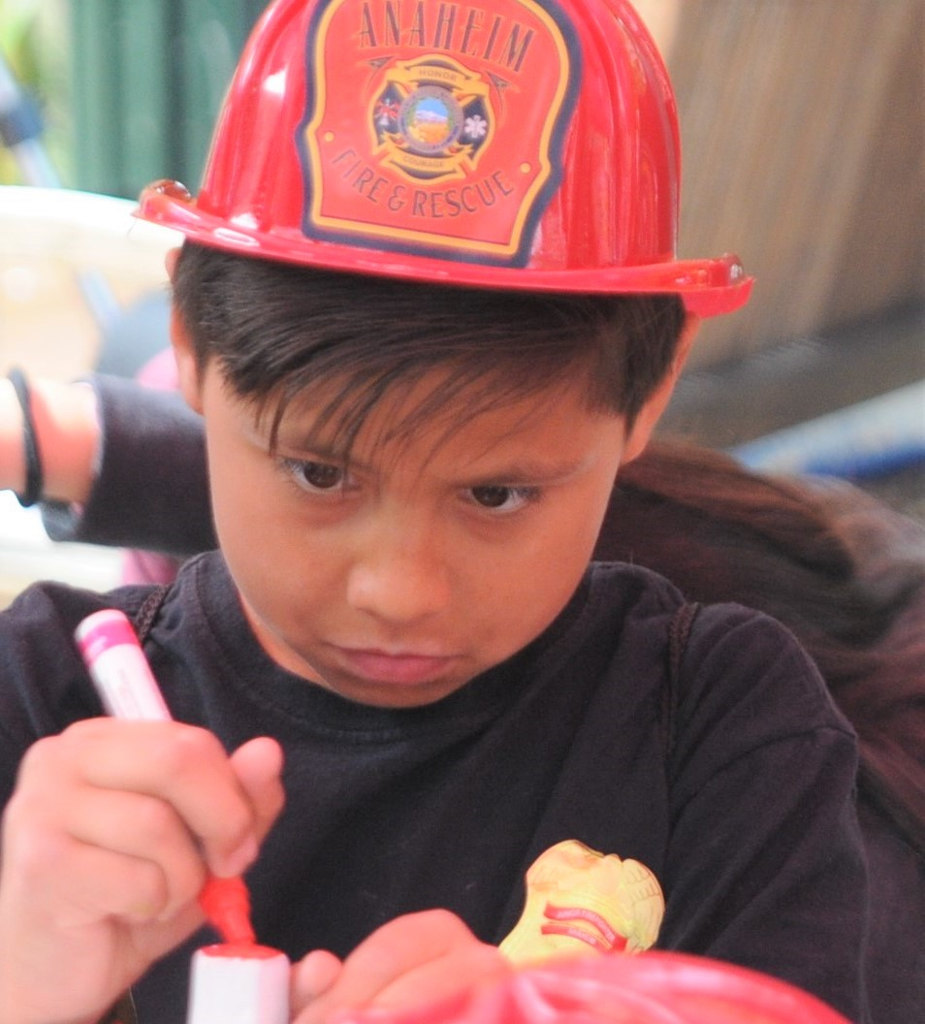 Noah, a youngster from the Boys & Girls Club of Anaheim applies his artistry on a repurposed fire hydrant, which will then be auctioned off as a fundraiser for the club and other youth programs. Photo by Lou Ponsi/Behind the Badge