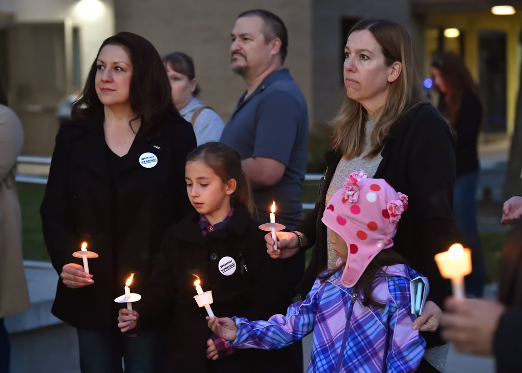 Christina, left, and Chris participate in a candlelight vigil with Sophia, 7, and Ashley, 7, right, at the conclusion of a prayer vigil for Whittier PD Officer Keith Boyer at the GGPD Police Officer Memorial. Photo by Steven Georges/Behind the Badge OC