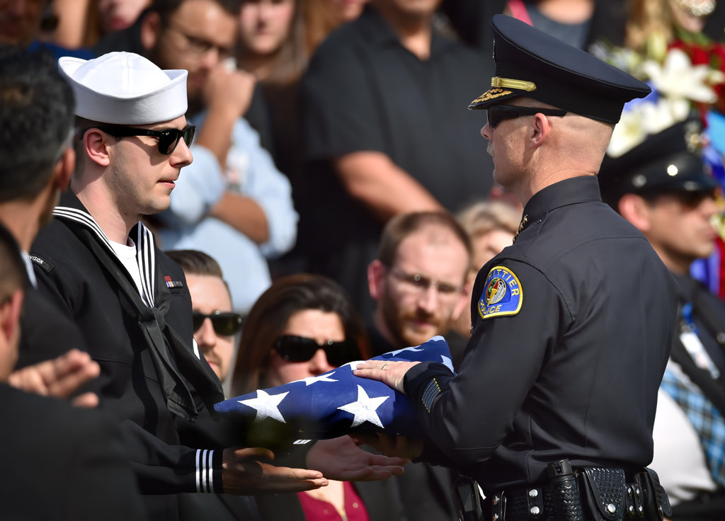 Whittier Police Chief Jeff Piper presents the ceremonial flag to Officer Keith Boyer’s son, Joseph Boyer, at the conclusion of funeral services. Photo by Steven Georges/Behind the Badge OC