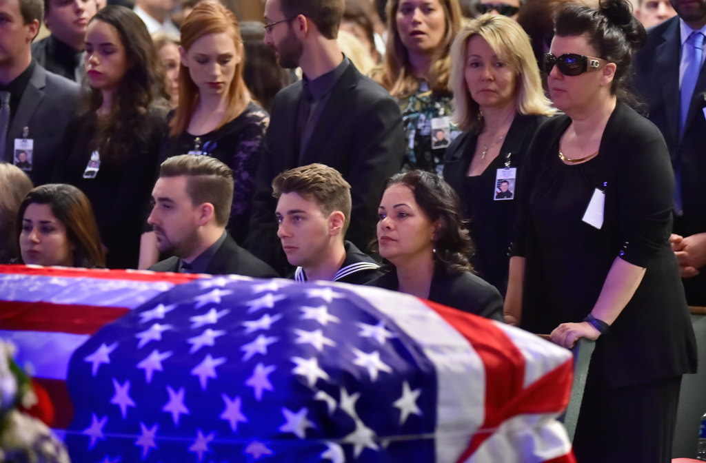 Joshua Boyer, Joseph Boyer and Ashley Sheleretis sit behind the casket of their father, Whittier PD Officer Keith Boyer, during memorial services at Calvary Chapel Downey. Photo by Steven Georges/Behind the Badge OC