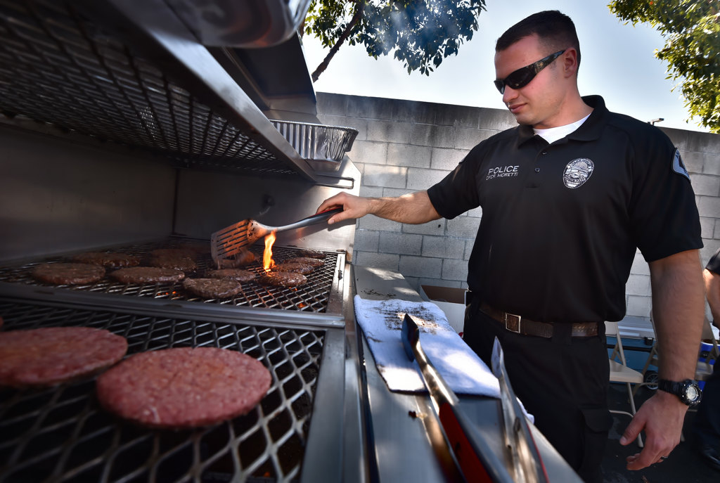 Anaheim PD Officer Kevin Moretti grills hamburgers to be handed out free for those who sign-up as bone marrow donors. Photo by Steven Georges/Behind the Badge OC