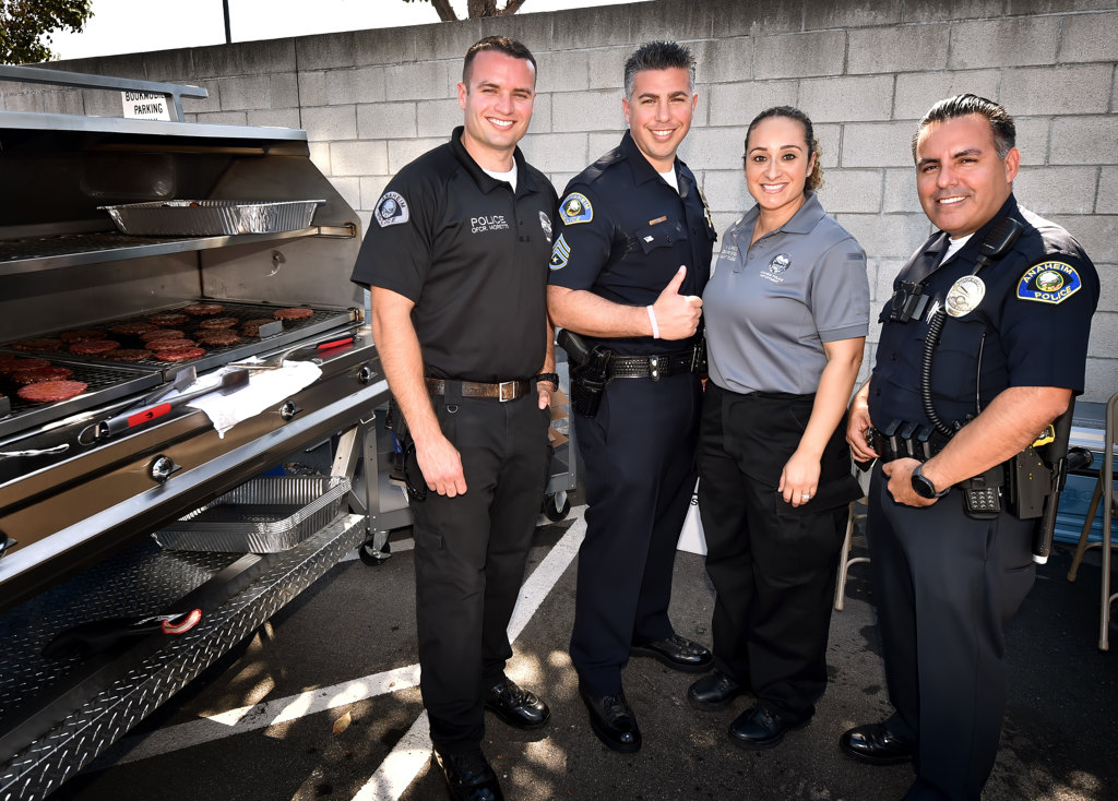 Anaheim PD Officer Kevin Moretti, left, Sgt. Daniel Gonzalez, APD Crime Prevention Specialist Rocio Burress and Officer Cesar Vazquez were among those helping out with the APD Bone Marrow Donor Registry Drive at the Anaheim Central Library. Photo by Steven Georges/Behind the Badge OC