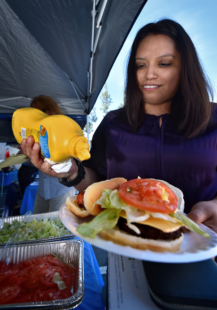 Elena Camacho of Anaheim Fire & Rescue (GIS Technician) receives a free BBQ lunch after signing up as a bone marrow donor during the APD donor drive. Photo by Steven Georges/Behind the Badge OC