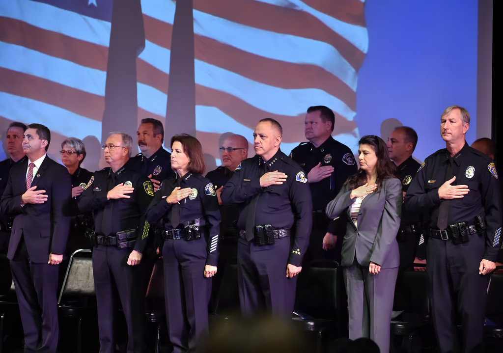 Police chiefs from various agencies and other guests stand for the Pledge of Allegiance at the start of GWC police academy graduation ceremonies. Photo by Steven Georges/Behind the Badge OC