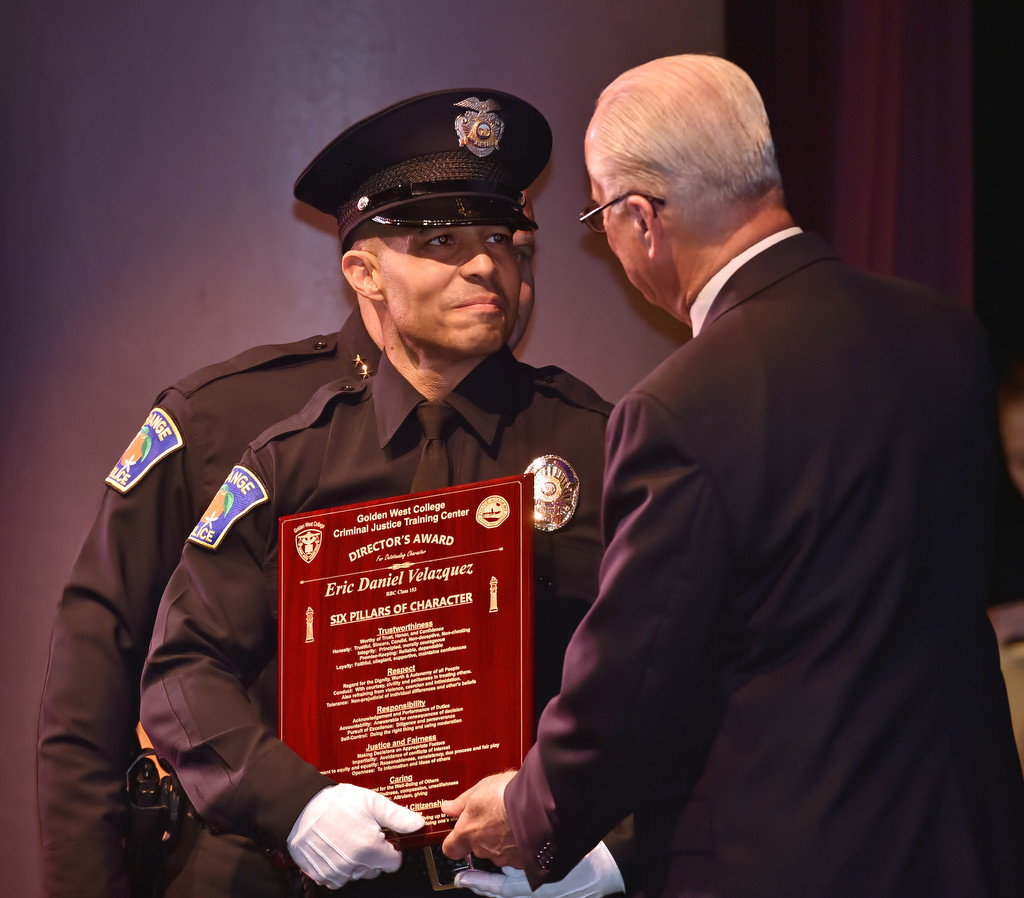 Ron Lowenberg, dean/director of the GWC Criminal Justice Training Center, presents the Director’s Award to Orange PD Recruit Eric Velazquez during the GWC Police Academy class of 153 graduation ceremony. Photo by Steven Georges/Behind the Badge OC