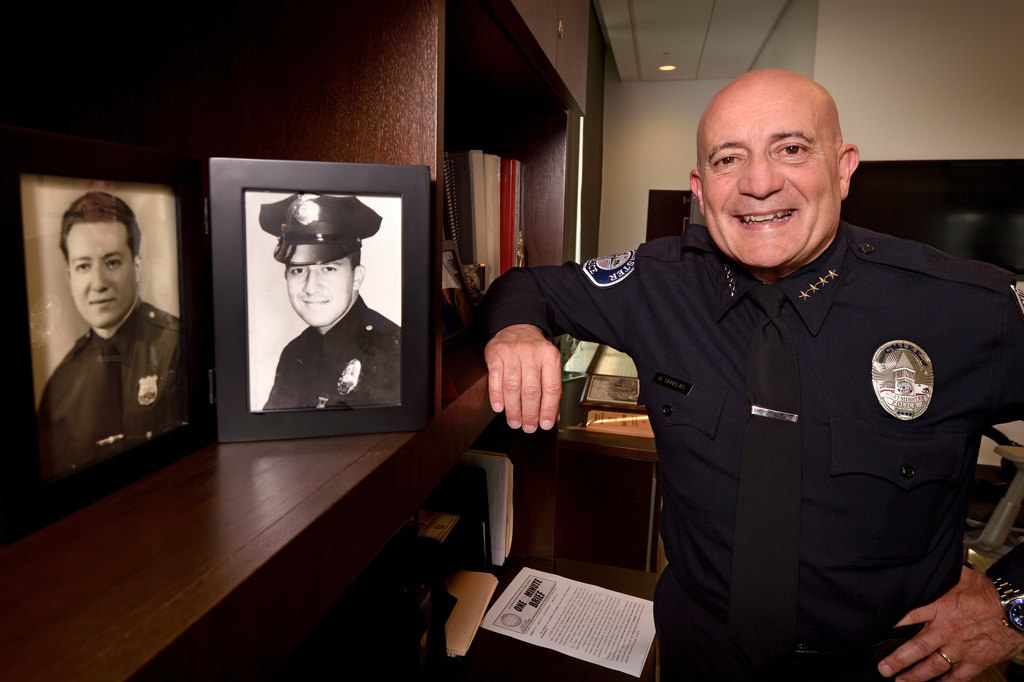 Westminster PD’s new Police Chief Ralph Ornelas with photos he has in his office of his father, Rafael Ornelas of NYPD, left, and his Uncle Gabriel Ornelas of LAPD. Photo by Steven Georges/Behind the Badge OC