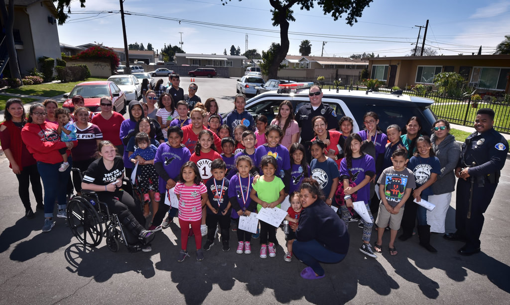Kids gather at the Palma Vista neighborhood with Garden forGrove PD officers Taylor Macy and Ralph Lee, right, during the Junior Neighborhood Watch Club kick-off event. Photo by Steven Georges/Behind the Badge OC